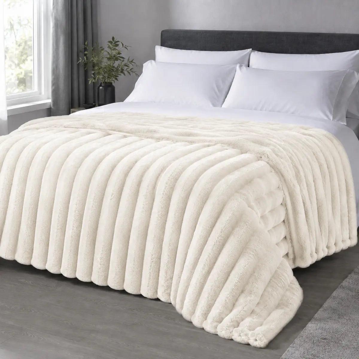Cream ribbed faux fur blanket draped over a bed