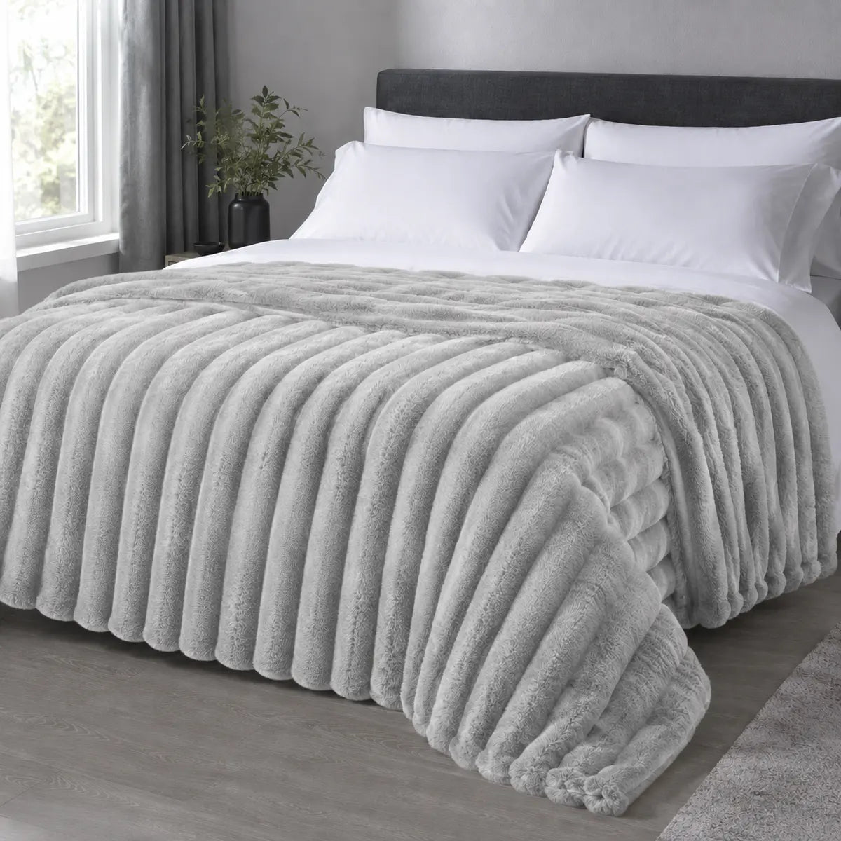 Platinum ribbed faux fur blanket draped over a bed