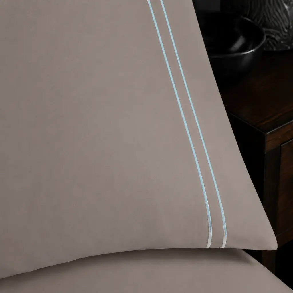 Close-up of a Stone Polycotton Percale 200TC pillowcase edge with two row of Duck Egg satin stitch.