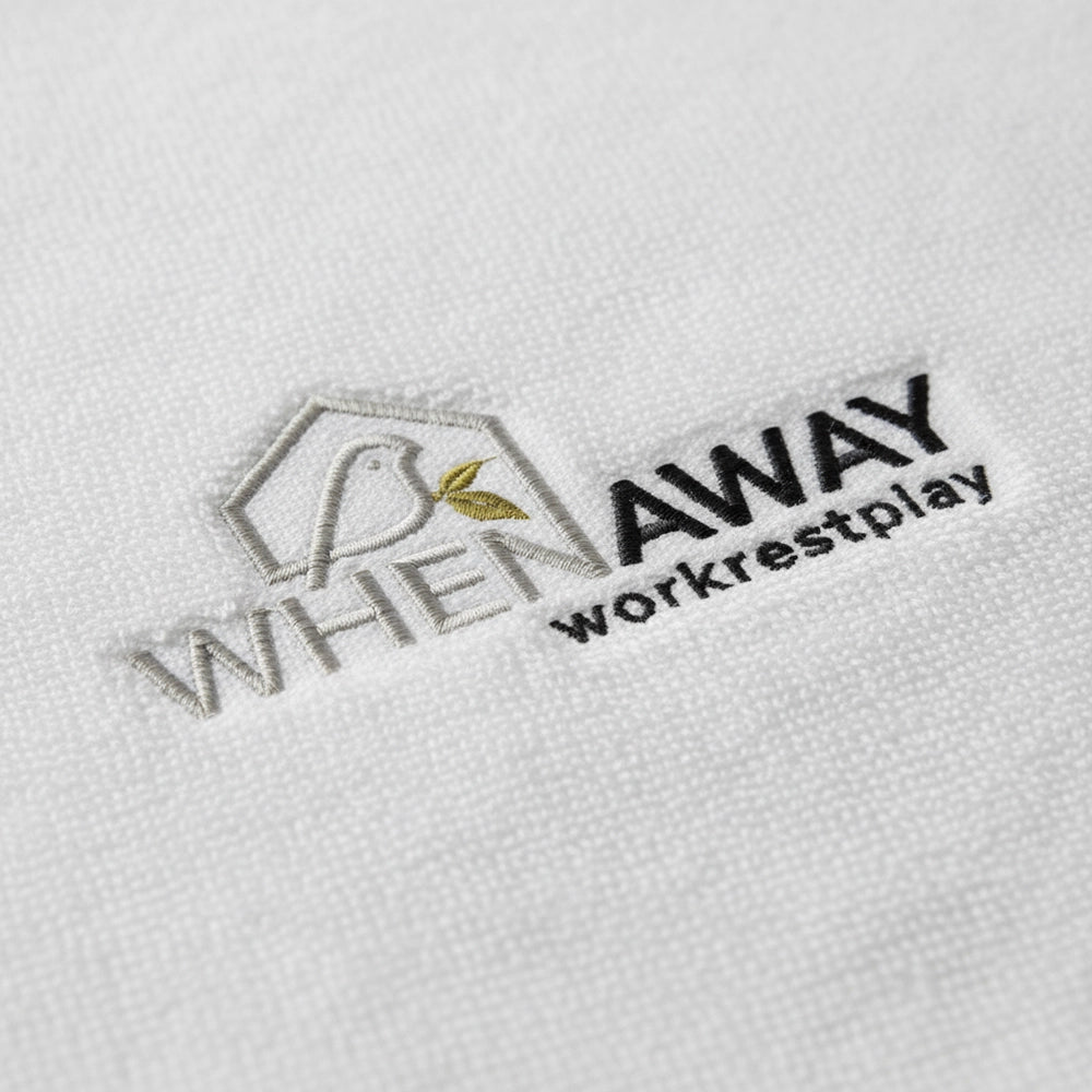 Custom embroidered logo on white towelling by Linen and Co - premium hospitality towel branding detail