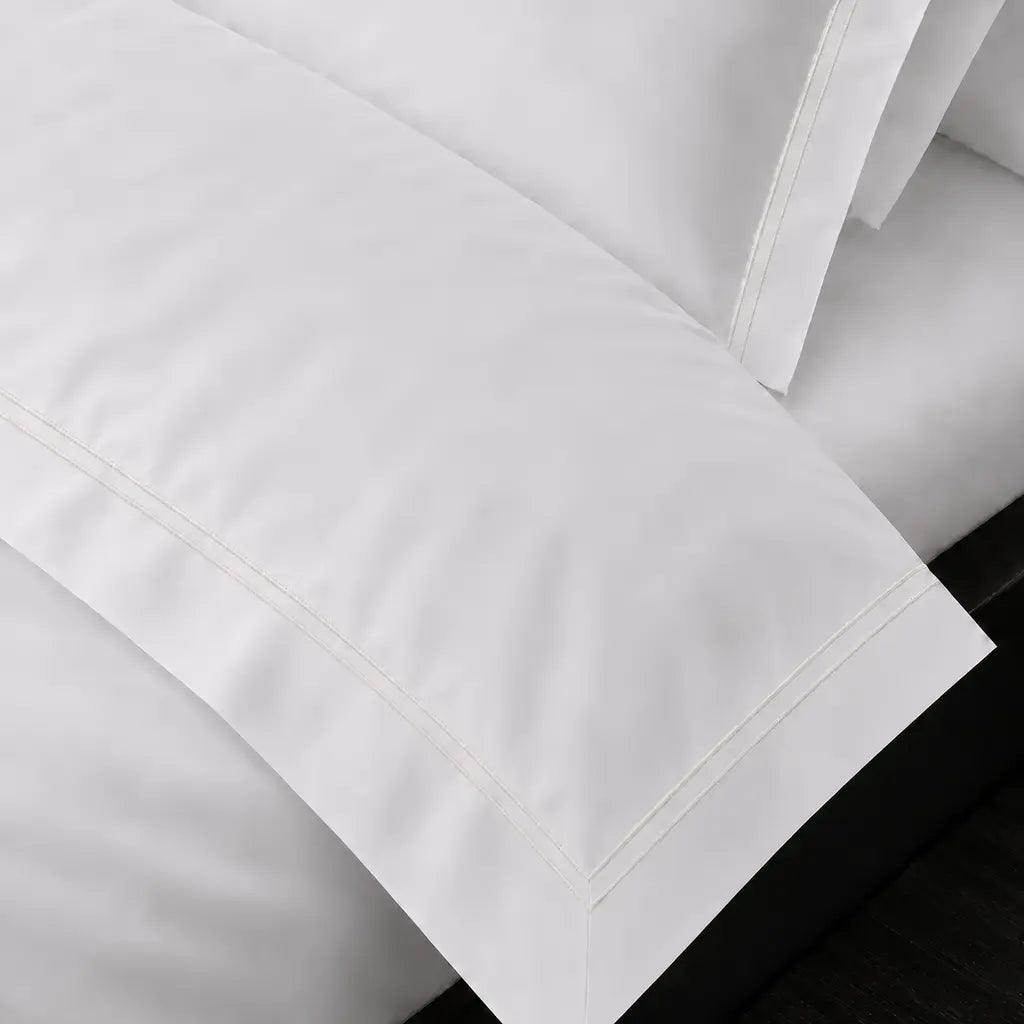 White Cotton 300TC Oxford duvet cover set with two row cream satin stitch — on-bed detail — Linen & Co