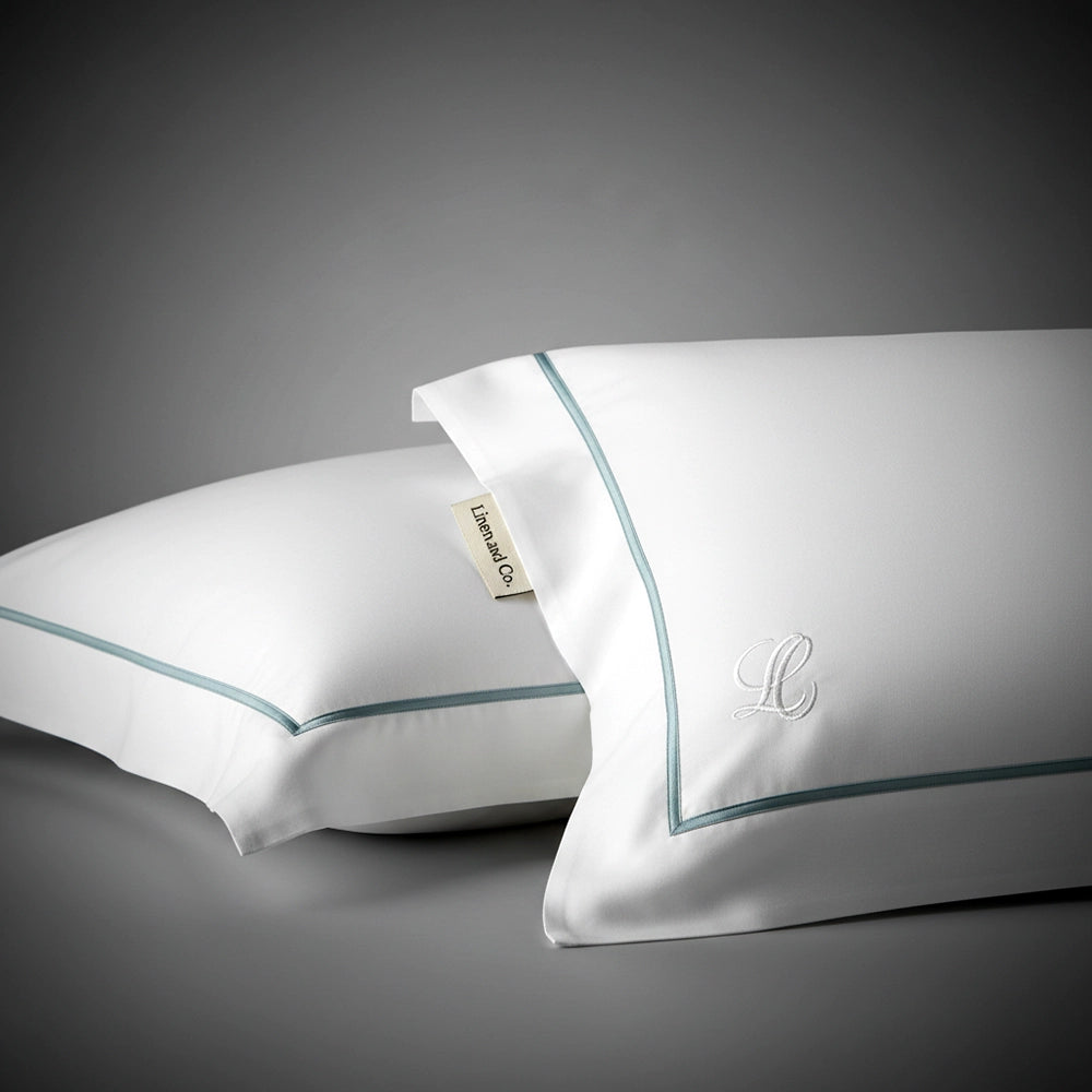 White pillowcase with satin stitch trim and embroidered monogram by Linen and Co, featuring luxury hospitality bed linen detail